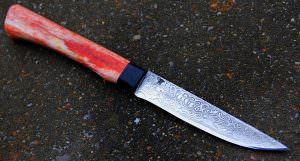 Puukko lame de 11 cm forgée en damas , garde et en ébène , manche en os stabilisé teinté disponible