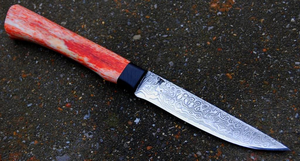 Puukko lame de 11 cm forgée en damas , garde et en ébène , manche en os stabilisé teinté disponible